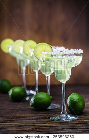 Margaritas And Ripe Limes.four Glasses In Row With Classical Margarita