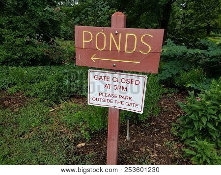 Wood Sign That Says Ponds And Gate Closed At 5pm