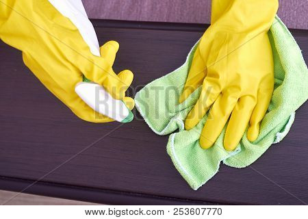 A Picture Of Hands In Yellow Gloves Cleaning The Wooden Surface