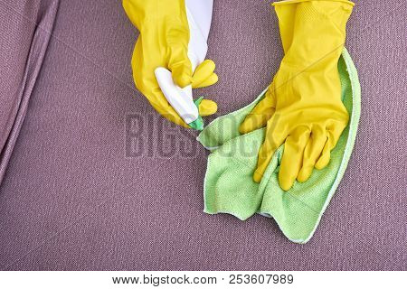 A Picture Of Hands In Yellow Gloves Cleaning The Sofa