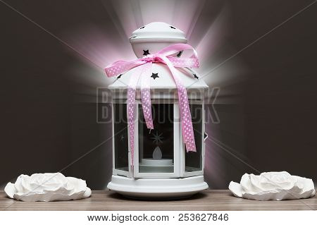 White Candile With Pink Ribbon And White Stone Flowers. Gift Concept On Dark Wood Background