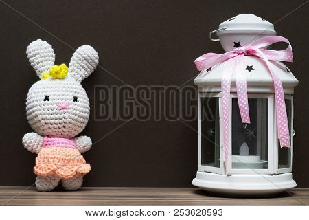 Fabric White Rubbit Toy And White Candile With Pink Ribbon. Gift Concept On Dark Wood Background