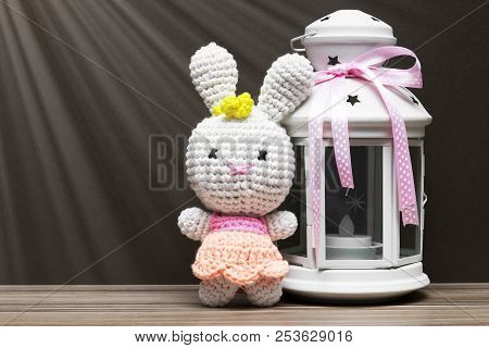 Fabric White Rubbit Toy And White Candile With Pink Ribbon. Gift Concept On Dark Wood Background