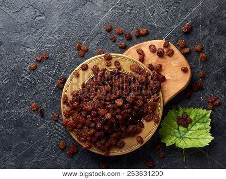 Heap Of Brown Raisins On Plate. Top View Of Dried Grapes With Copy Space.