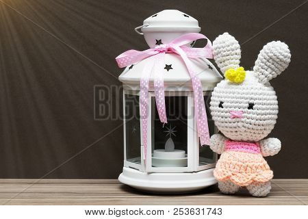 Fabric White Rubbit Toy And White Candile With Pink Ribbon. Gift Concept On Dark Wood Background
