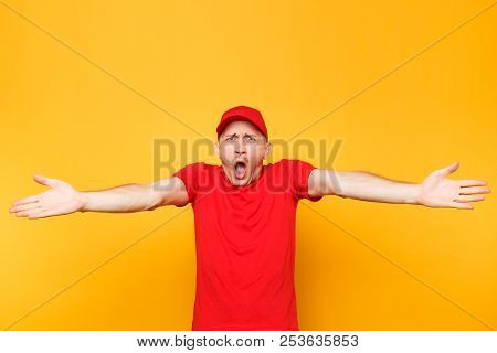 Delivery Man In Red Uniform Isolated On Yellow Orange Background. Professional Perturbed Shocked Mal