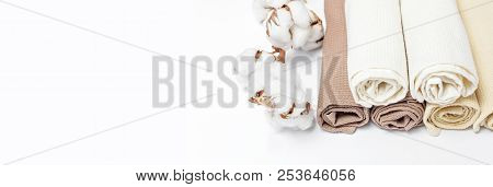 Multicolored Clean Towels With A Branch Of Cotton On A White Background Top View With Copy Space. Te