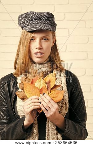 Fashion Model With Stylish Hair In Hat. Woman With Autumn Leaves In Leather Jacket. Beauty And Fashi