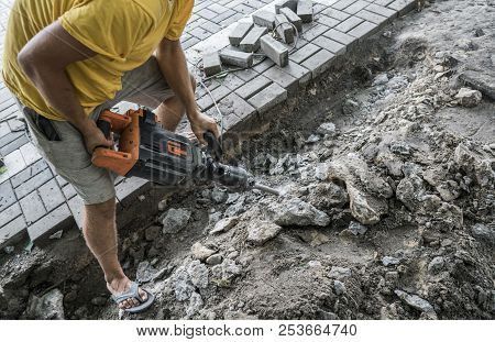 Workers Use Electric Concrete Breaker. Male Worker Repairing Driveway Surface With Jackhammer, Diggi