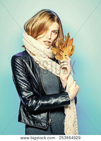 Beauty And Fashion. Woman With Autumn Leaves In Leather Jacket. Girl With Orange Leaves On Blue Back