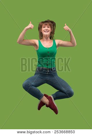 Freedom In Moving. Mid-air Shot Of Pretty Happy Young Woman Jumping And Gesturing Against Orange Stu