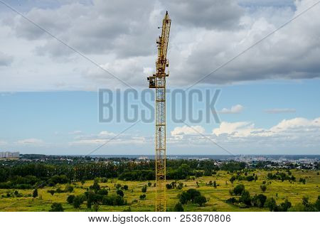 The Construction Crane Works At The Construction Site. A Single Construction Crane. Yellow Stoic. Si