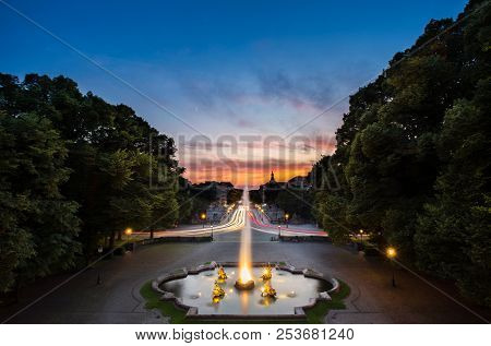 Fountain At Friedensengel, Where Is The Famous Landmark With Light Trail Of Car Of Transportation On
