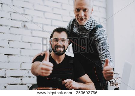 Two Exited Smiling Men In Uniform In Workshop. Repair Shop. Thumbs Up. Computer Hardware. Young And 