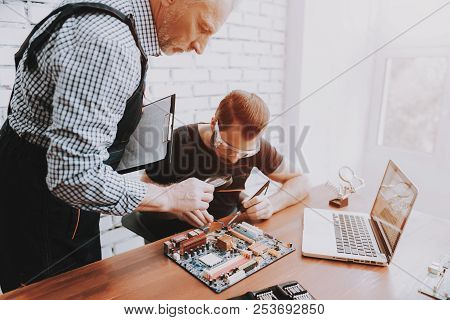 Two Men Repairing Hardware Equipment In Workshop. Repair Shop. Worker With Tools. Computer Hardware.