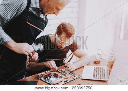 Two Men Repairing Hardware Equipment In Workshop. Repair Shop. Worker With Tools. Computer Hardware.