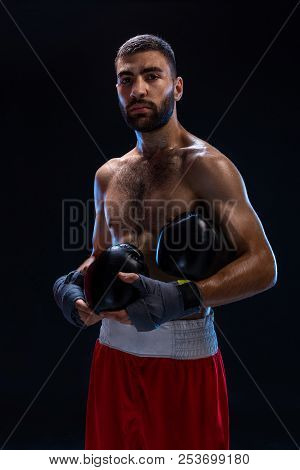 Handsome Athletic Guy In A Red Shorts On A Black Background. The Boxer Is Fetching His Breath After 