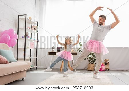 Funny Father And Daughter In Pink Tutu Skirts Dancing Like Ballerinas
