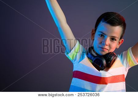 Cute Boy With Headphones On Color Liht Background
