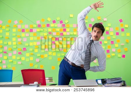 Man in the office with many conflicting priorities doing exercis