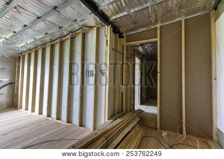 Room Under Construction And Renovation With Silver Aluminum Foil On Walls And Ceiling, Oak Floor And