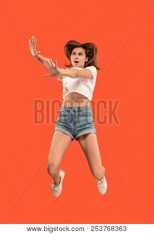 Freedom In Moving. Mid-air Shot Of Pretty Happy Young Woman Jumping And Gesturing Reject Against Ora