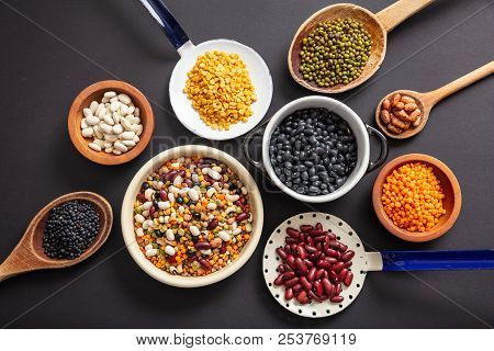 Top View Of Fflat Lay Of Assortment Of Legumes On Black Tabletop Background, In Scoop, Enameled Bowl