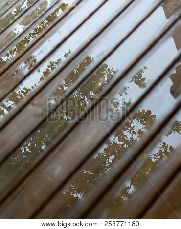Wet Cottage Deck. Reflections In Puddles On Wooden Planks After Summer Rain. Background