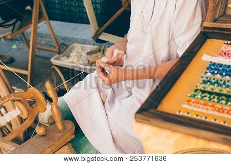 Close Up Of A Cropped View Of A Woman Spinner Transforming Wool With A Wooden And Vintage Spinning W