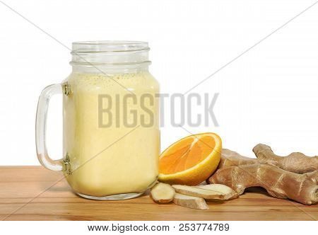 Tonifiyng Smoothie In A Mason Jar With Ingridientes On A Wooden Cutting Board With White Background.
