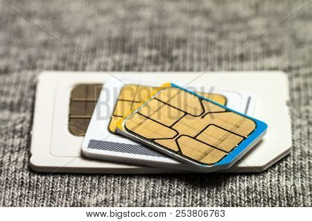 Set Of Mini, Micro And Nano Simcard. Isolated On Grey Cloth Texture Background