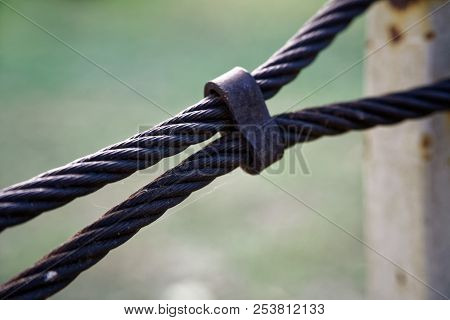 Thick Steel Rope Close Up. Bridge Fence Element. Detailed View. The Surface Of The Steel Cable Is Co