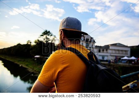 Guy In Front Of Blue Sky At Evening Time Admire Landscape. Enjoy Pleasant Moment. Man In Cap Enjoy S