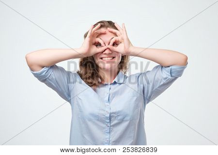 Pretty Girl With Surprised Face Holding Fingers Near Eyes Like Glasses: Mask Like Super Hero Or Owl