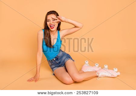 Full-size Portrait Of Brunette Cute Funky Trandy Girl Sits On The Floor In Pink Roller Skates Leanin