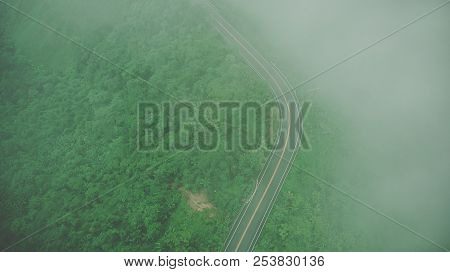 Aerial Top View Of Sky Road Over Top Of Mountain With Fog And Green Jungle After Raining In Morning