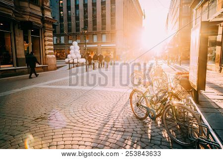 Helsinki, Finland. Bicycles Parked Near Storefronts In Kluuvikatu Street. View Of Street In Sunlight