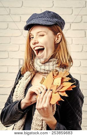 Season And Autumn Holiday. Girl With Orange Leaves At Brick Wall. Woman With Autumn Leaves In Leathe