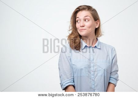 Close Up Portrait Of Pretty Confident Thoughtful Girl Looking Like Conspirator Standing Over Grey Ba