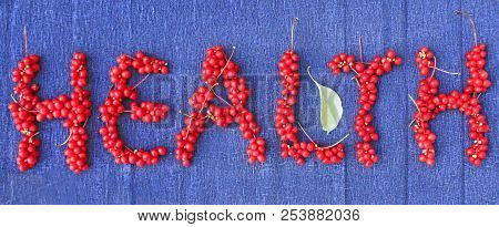 Word Health From Red Ripe Berries Of Schisandra On Dark Blue Background. Healthful Schisandra