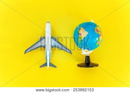 Flat Lay With Plane And Globe On Yellow Colourful Trendy Modern Fashion Background. Vacation Travel 