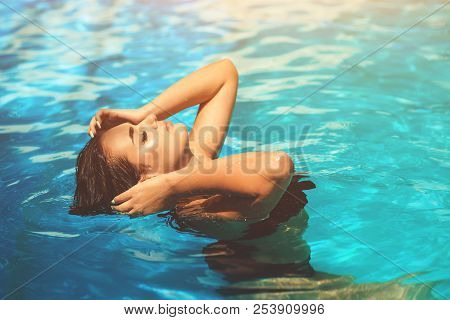 Fashion Photo Of Sexy Beautiful Girl With Brunette Hair In Elegant Bikini Sunbath In Swimming Pool.