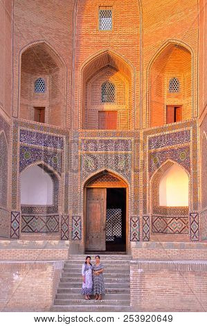 Bukhara, Uzbekistan - May 8, 2011: Two Uzbek Women Posing At The Entrance Of Mir-i Arab Madrasa