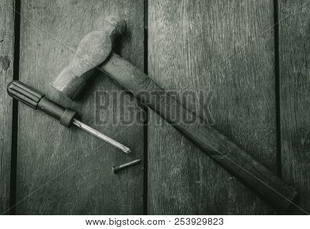 Top View Of Old Hammer, Screwdriver And Nail On Old Wooden Table. Woodwork Tools For Fix And Repair 