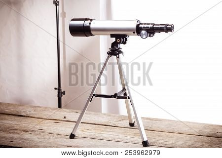 Telescope On A White Background Laid On Wooden Board