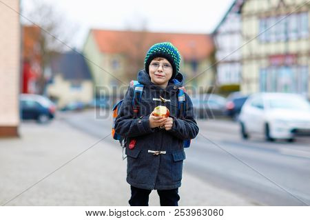 Little Kid Boy With Eye Glasses Walking From The School And Eating Apple