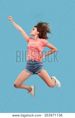 Freedom In Moving. Move Only Forward. Pretty Happy Young Woman Jumping And Gesturing Against Blue St