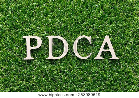 Wood Alphabet In Word Pdca (plan Do Check Act) On Artificial Green Grass Background