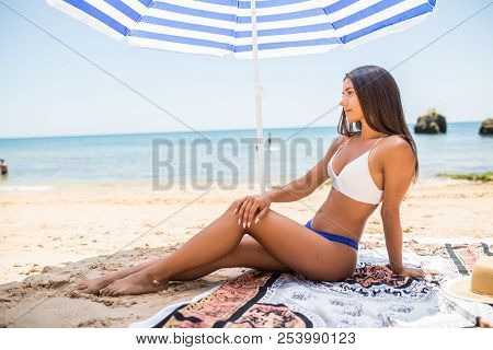 Young Beauty Latin Woman Lying On The Sand Under Sun Umbrella On The Sea Beach. Summer Vocation
