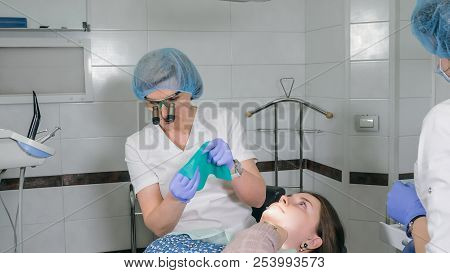 Woman At Dentist Clinic Gets Dental Treatment To Fill A Cavity In A Tooth. Dental Restoration And Co